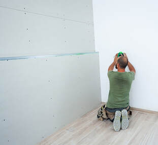 one man installing drywall