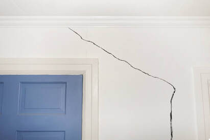 long crack in drywall above blue door